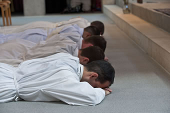 Five young monks prostrate before ordination (2010).