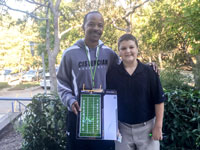 Coach Dotson and the winner of the 7th Grade Design-a-Play auctioned at Homecoming.